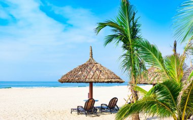 Grup şezlonglar kumsal deniz tropikal güneşli bir günde bir şemsiye altında