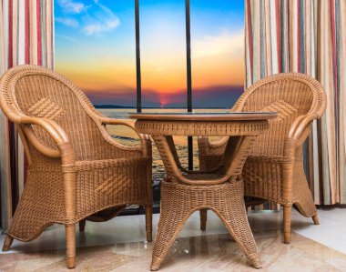 hasır rattan mobilya bir Resort otel odasının penceresinden gün batımı görünümü