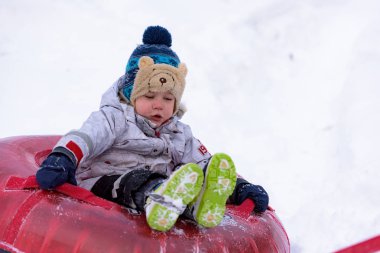  Karda oynarken bir yastıklı ceket ve örgü şapka giyen eğleniyor portre küçük çocuk çocuk.