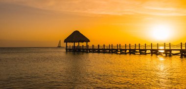 bir iskele ile denizde güzel turuncu gün batımı