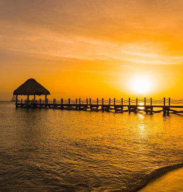 bir iskele ile denizde güzel turuncu gün batımı