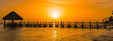 bir iskele ile denizde güzel turuncu gün batımı