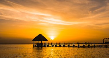 bir iskele ile denizde güzel turuncu gün batımı