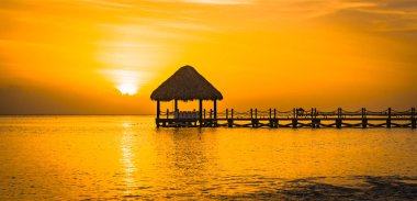 bir iskele ile denizde güzel turuncu gün batımı