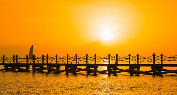 Vacker apelsin solnedgång på havet med en brygga — Stockfoto
