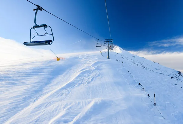 산악 스키 리조트의 눈 덮인 스키 슬로프 및 의자 스키 리프트 스테이션. — 스톡 사진