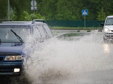Hareket eden araba yağmuru Tekerleklerden fışkıran su birikintisi