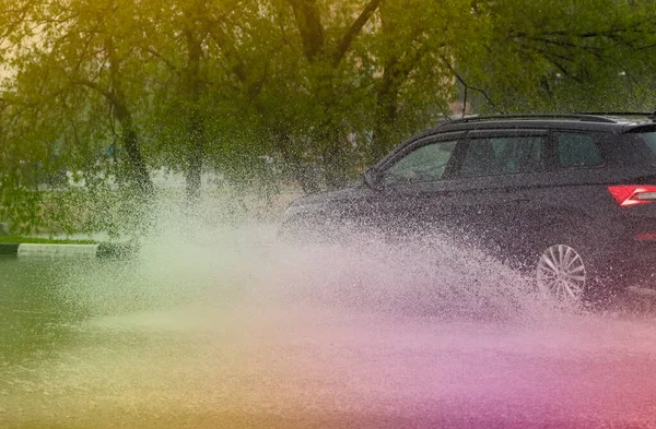 Hareket eden araba yağmuru Tekerleklerden fışkıran su birikintisi