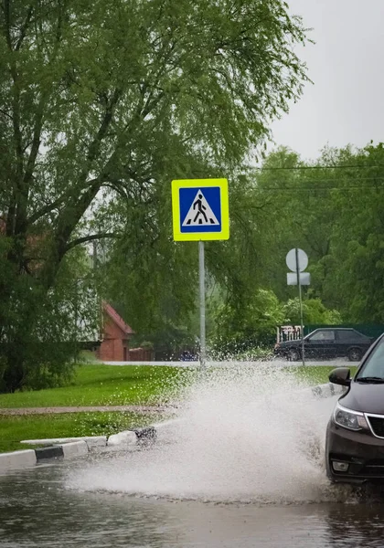 자동차에 빗발치는 물보라가 바퀴에서 쏟아진다 — 스톡 사진