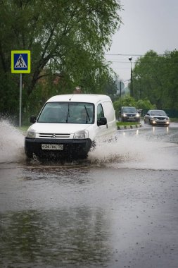 - Rusya. Moskova. 30 Mayıs 2020. Bir araba su birikintisinin içinden su sıçratarak geçiyor. Şehirde bahar seli.