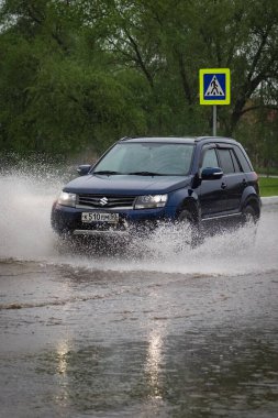 - Rusya. Moskova. 30 Mayıs 2020. Bir araba su birikintisinin içinden su sıçratarak geçiyor. Şehirde bahar seli.