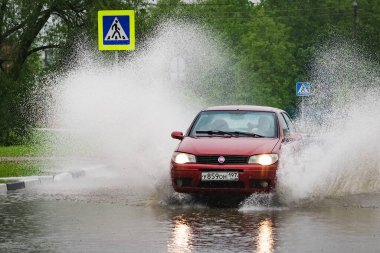 - Rusya. Moskova. 30 Mayıs 2020. Bir araba su birikintisinin içinden su sıçratarak geçiyor. Şehirde bahar seli.