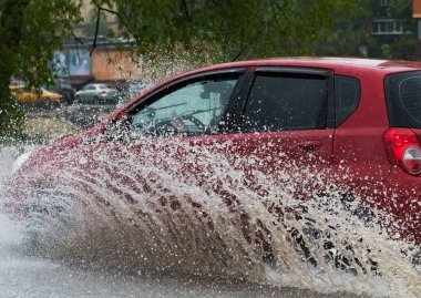 - Rusya. Moskova. 30 Mayıs 2020. Bir araba su birikintisinin içinden su sıçratarak geçiyor. Şehirde bahar seli.