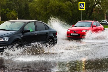- Rusya. Moskova. 29 Mayıs 2020. Bir araba su birikintisinin içinden su sıçratarak geçiyor. Şehirde bahar seli.