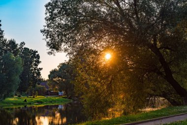 Sabahın erken saatlerinde, bir göletin üzerinde, renkli şafak...