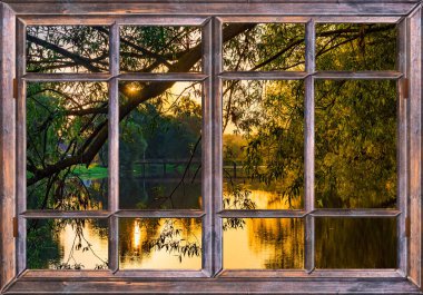 Sabahın erken saatlerinde pencereden gölet ve ağaçların üzerinden...