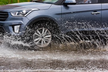 Hareket eden araba yağmuru Tekerleklerden fışkıran su birikintisi
