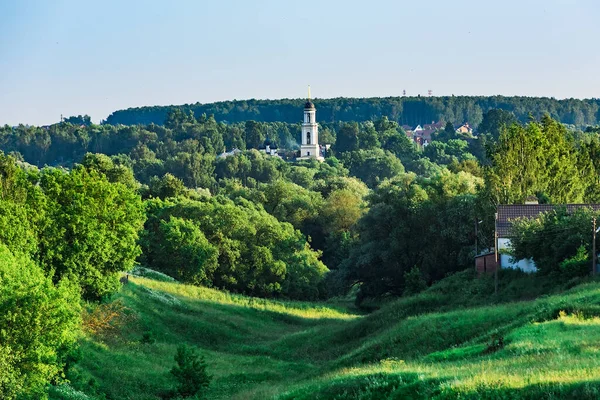 Venkovská Krajina Zarostlá Zelenou Trávou Stromy Zvonice Křesťanského Kostela Pozadí — Stock fotografie