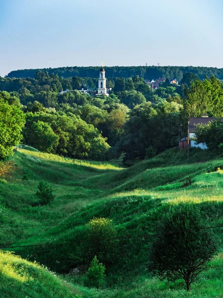 Venkovská Krajina Zarostlá Zelenou Trávou Stromy Zvonice Křesťanského Kostela Pozadí — Stock fotografie