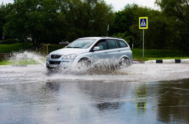 - Rusya. Moskova. 30 Mayıs 2020. Bir araba su birikintisinin içinden su sıçratarak geçiyor. Şehirde bahar seli.