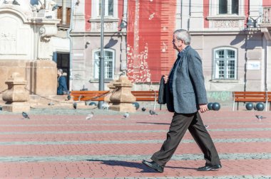 Timisoara, Romanya - 15 Mart 2018: yaşlı adam sokakta yürürken. Gerçek insanlar. Arkadan Görünüş.