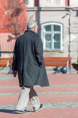 Yaşlı adam sokakta yürürken. Gerçek insanlar. Arkadan görüntülemek