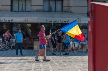 TIMISOARA, ROMANIA - 10 Ağustos 2018: Hükümet karşıtı protestoda Romanya bayrağı taşıyan kadın ve erkek