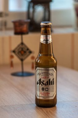 Timisoara, Romanya - 20 Ağustos 2018: Asahi bira şişesi üzerinde ahşap bir masa. Japon malı