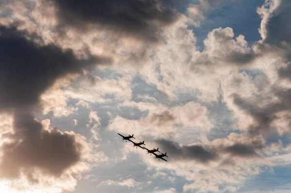 Aerobatics planes flying in the sky with clouds in the background