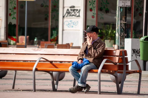 Timisoara Rumania Abril 2016 Hombre Sentado Banco Fumando Cigarrillo Calle — Foto de Stock