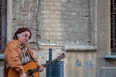 Timisoara, Romanya - 2 Nisan 2016: Adam sokakta şarkı söylüyor ve gitar çalıyor. Gerçek insanlar..