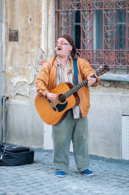 Timisoara, Romanya - 2 Nisan 2016: Adam sokakta şarkı söylüyor ve gitar çalıyor. Gerçek insanlar..
