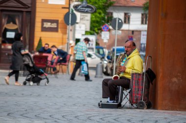 Timisoara, Romanya - 13 Nisan 2016: Sokakta saksafon çalan adam. Gerçek insanlar..