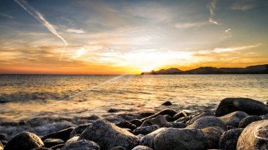 ön planda taşlarla odaklanmamış günbatımı