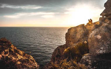 günbatımı kayalar denizin içinde belgili tanımlık geçmiş ile arasında