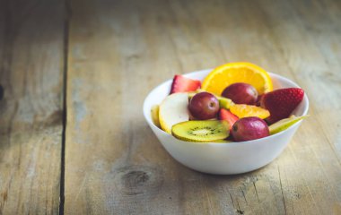 Mutfak eşyaları beyaz ve ahşap zemin üzerine stüdyo oturumdaki meyve salatası