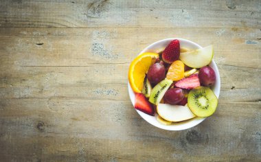 Mutfak eşyaları beyaz ve ahşap zemin üzerine stüdyo oturumdaki meyve salatası