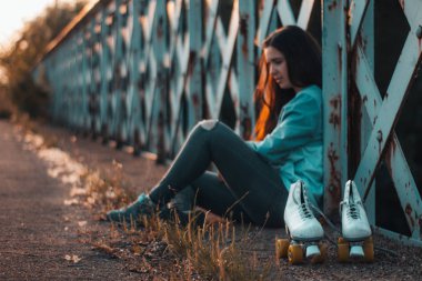 Bisiklet ve paten gün batımında eski demir köprü üzerinde oturum