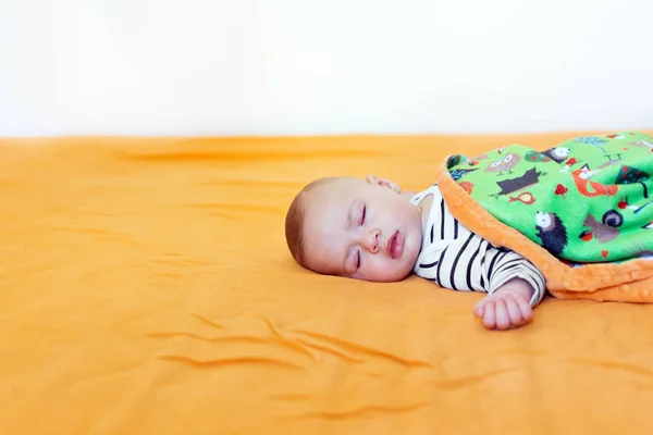 婴儿睡在橙色床单上 婴儿覆盖着柔软的毯子静静地睡觉 复制空间 自然光 — 图库照片