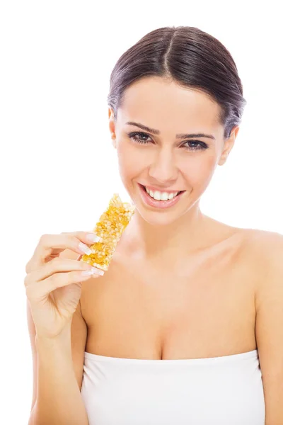 Όμορφη Νεαρή Γυναίκα Τρώει Granola Μπαρ Χαμογελώντας Χωρίς Ρετούς Απομονώνονται — Φωτογραφία Αρχείου