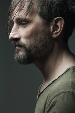 Erkek güzellik kavramı. Her yaşta çok iyi. 40 yaşındaki adam koyu gri arka plan üzerinde ayakta portresi. Alnına ıslak saç. Rocker, motorcu tarzı. Yakın çekim. Stüdyo vurdu