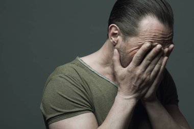 Yorgun adam, kötü hiçbir kavram görüyorum. 40-year-old güçlü acımasız adam koyu gri arka plan üzerinde duygusal portresi. Saç geri fırçaladı. Rocker, motorcu tarzı. Yakın çekim. Boşluk. Stüdyo vurdu