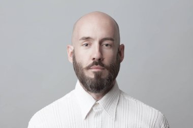 Her yaşta çok iyi. Işık gri arka plan beyaz gömlek üzerinde ayakta 40-year-old adam portresi. Yakın çekim. Klasik tarzı. Kel kafası tıraşlı. Boşluk. Stüdyo vurdu