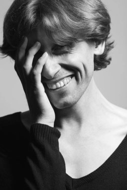 Erkek güzellik kavramı. Işık gri arka plan üzerinde ayakta olgun adam portresi. Uzun dalgalı saçlar. Klasik tarzı. Yakın çekim. Studio tek renkli shot