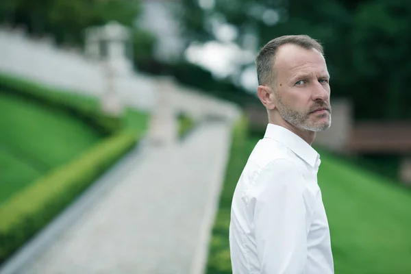 在任何年龄的美妙 45岁男子的肖像站在欧洲公园背景白色衬衫 关门了经典风格 文本空间 户外射击 — 图库照片