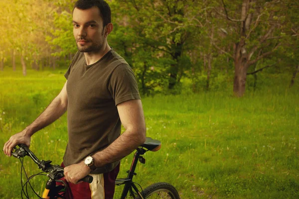 Concepto de estilo de vida saludable. Perfil retrato de joven guapo en bicicleta —  Fotos de Stock