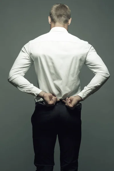 Male clothing concept. Back of young man with great figure undressing — Stock Photo, Image