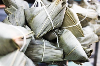 Çin geleneği gıda-buğulanmış pirinç hamur, Zongzi veya geleneksel Çin yapışkan pirinç köfte, geleneksel ejderha tekne Festivali gıda kavramı unwrapping Zongzi veya pirinç hamur. Asya gıda buharda yapışkan pirinç börek dolgular ile yeniden sarılmış