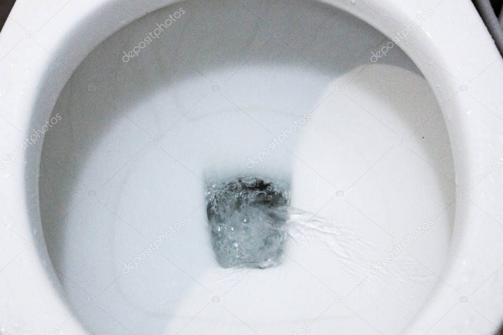 selective focus close up flushing toilet bowl for sanitary, Toilet, Flushing Water, close up, water flushing in toilet, A photo of a white ceramic toilet bowl in the process of washing it off. Ceramic sanitary ware for correcting the need with an aut