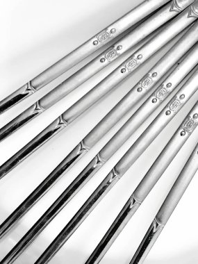 Beyaz arka planda paslanmaz çelik çubuklar, Paslanmaz çelikten yemek çubuklarının arka plan dizaynı.